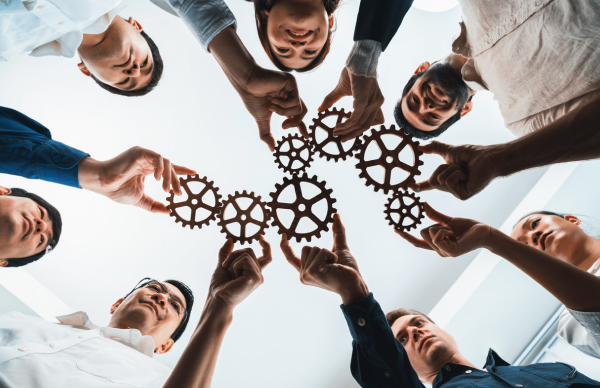 Advantages of working at Voltaira – Team & People Team holding cogs together